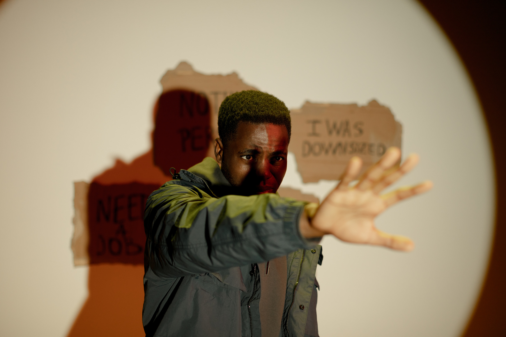 Black man raising his hand and job slogans behind him